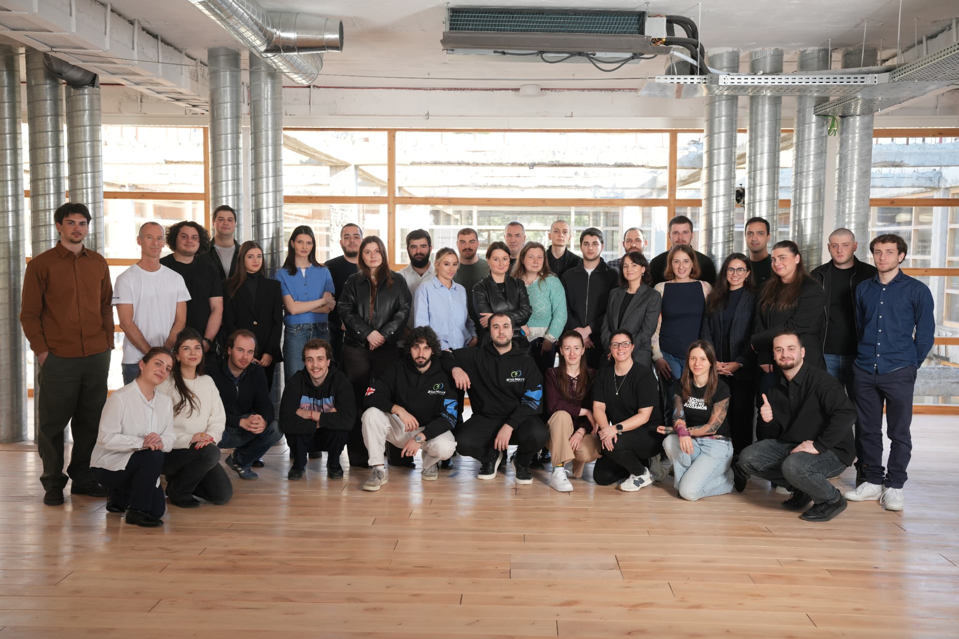 The 2026 Dare to Build cohort posing together in a bright loft space with wooden floors