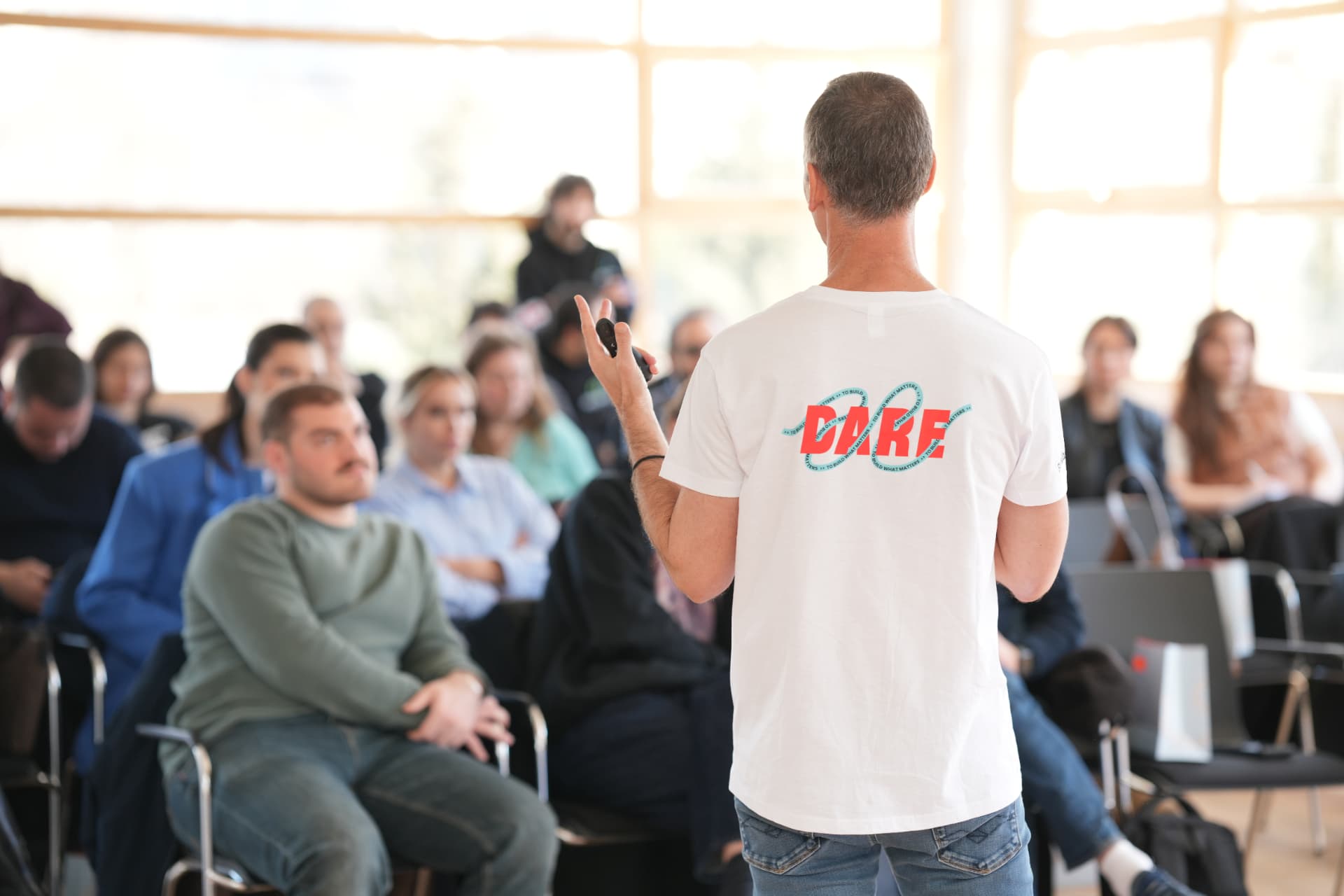 A Startupbootcamp Georgia session in progress, a speaker in a DARE t-shirt addressing seated founders